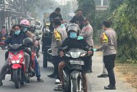 Kapolsek Pulau Bacan, Ipda Muhammad Anwar, S.H., bersama personel kepolisian membagikan 70 masker kepada pengendara dan pengguna jalan di depan Mako Polsek Pulau Bacan, mulai pukul 08.20 hingga 08.50 WIT. Rabu, (14/10/26). Dok. Ian. 