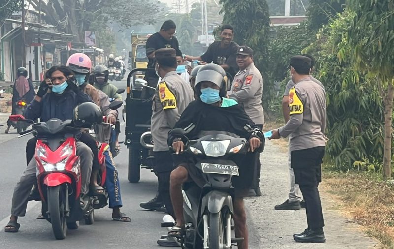 Kapolsek Pulau Bacan, Ipda Muhammad Anwar, S.H., bersama personel kepolisian membagikan 70 masker kepada pengendara dan pengguna jalan di depan Mako Polsek Pulau Bacan, mulai pukul 08.20 hingga 08.50 WIT. Rabu, (14/10/26). Dok. Ian. 